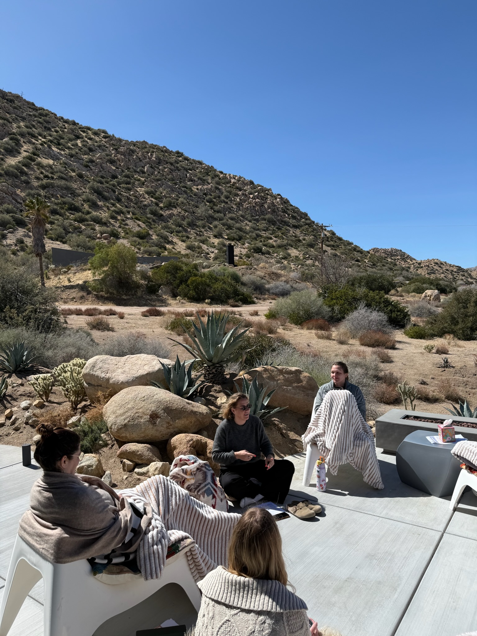 Women gathered outdoors in the desert for a retreat circle