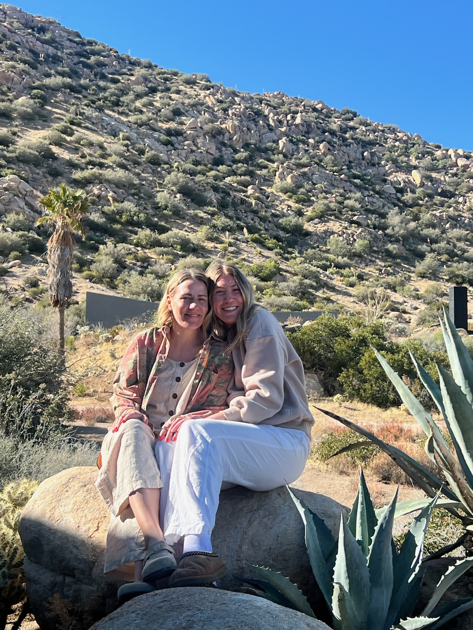 Two women smiling together in the desert landscape